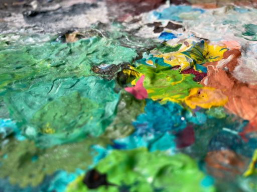 Bunte Farbkleckse auf einer Palette in verschiedenen Grüntönen und Akzenten.